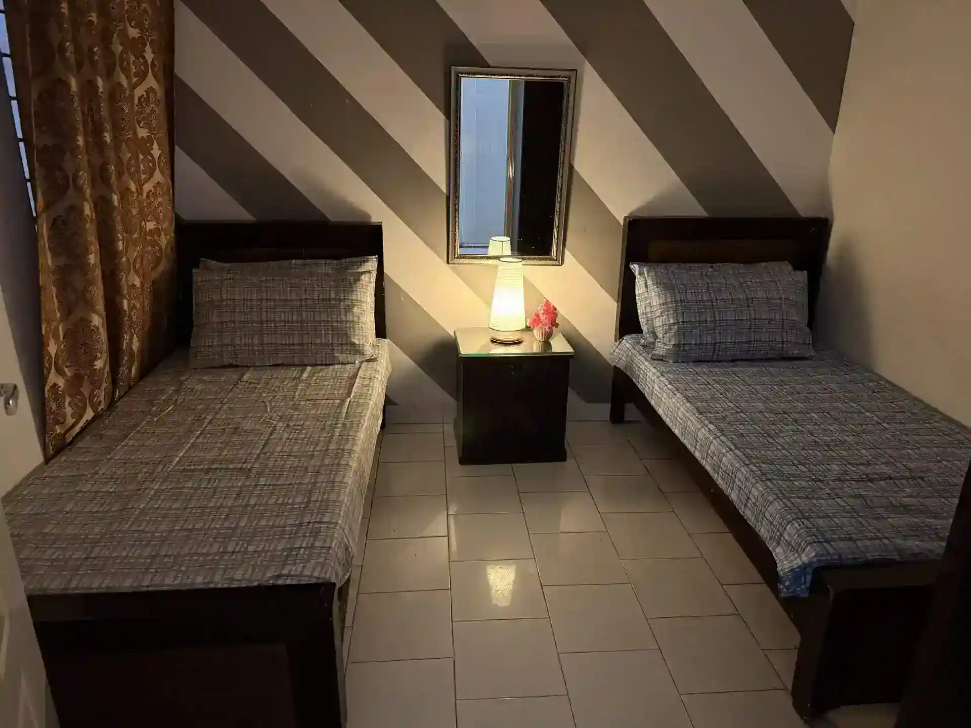Cozy hostel room with two single beds in Lahore Girls Hostel.