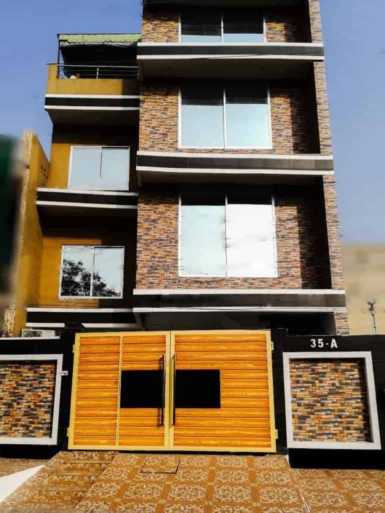 Modern multi-story Lahore Girls Hostel building with balconies and brick facade.